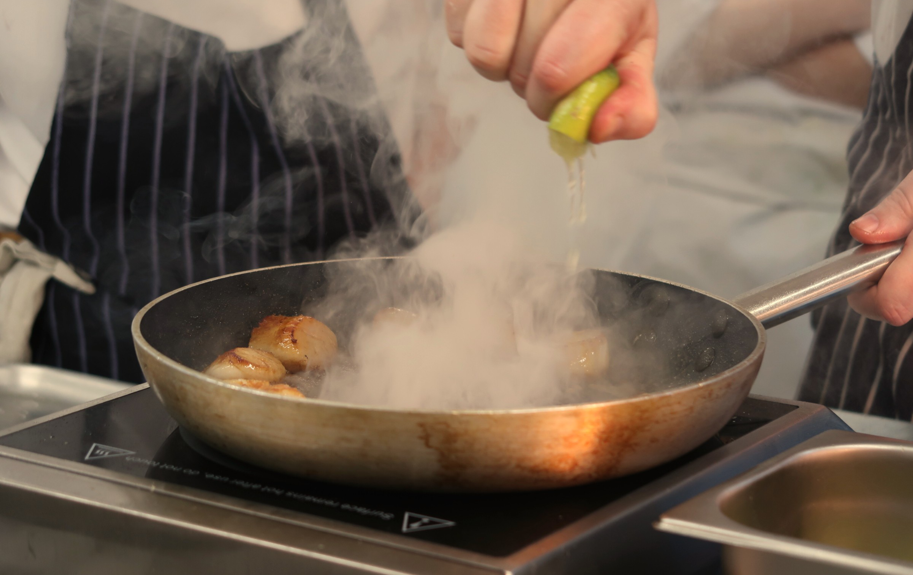 Lime Being Squeezed In Pan On Hob